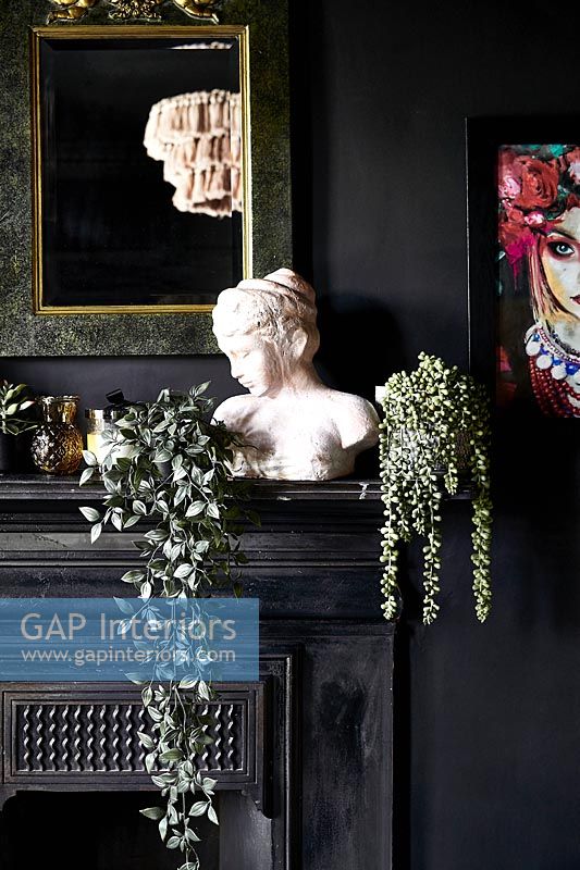 Classic bust on mantelpiece in black painted room 