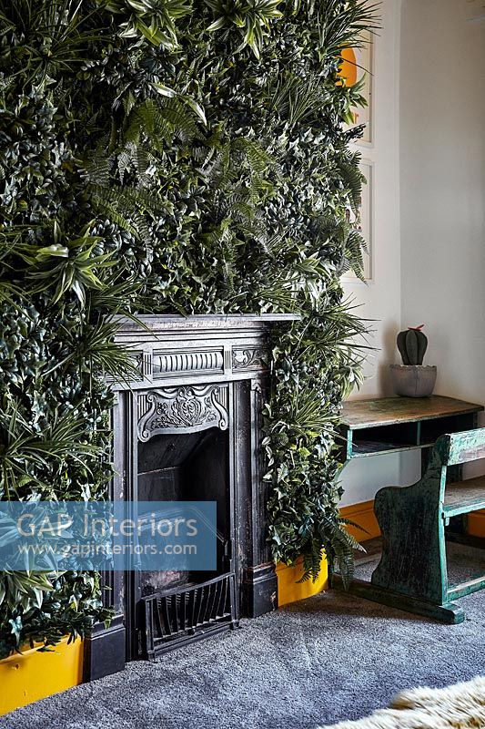 Green living wall around fireplace in modern childrens room 