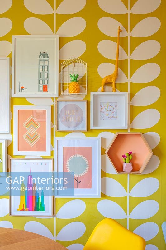 Framed pictures on colourfully wallpapered wall 