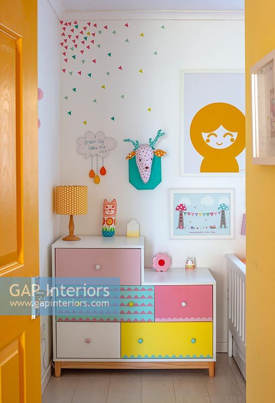 Colourful chest of drawers and artwork in childrens room 