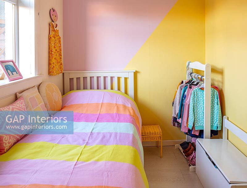 Blocks of differently coloured painted walls in modern childrens room 