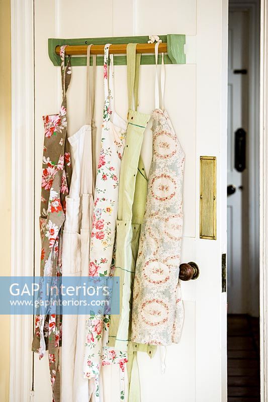 Floral aprons hanging on door 