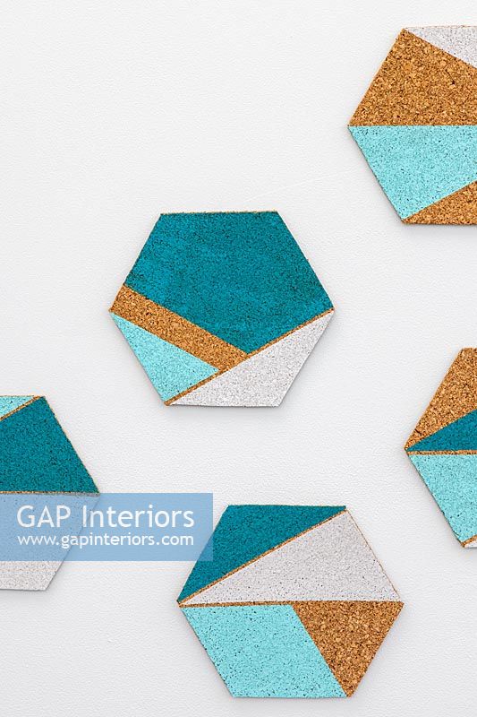 Hexagonal cork shapes with painted geometric areas used for wall decorations
