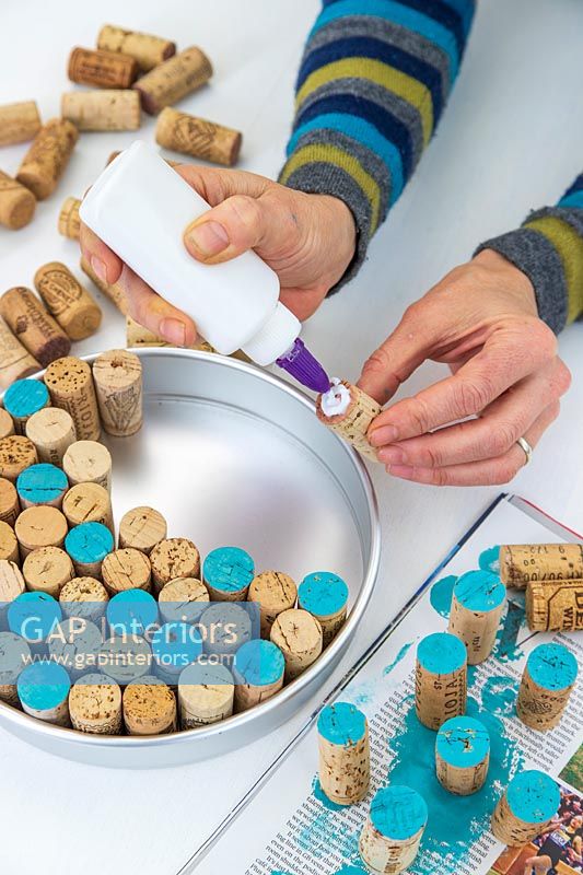 Woman gluing the corks into the cake tin to ensure they are fixed in place