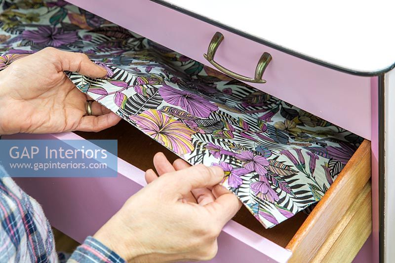 Complimentary patterned paper being added inside the drawers 