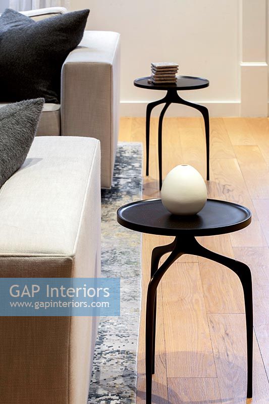 Detail of small black side tables in modern living room 