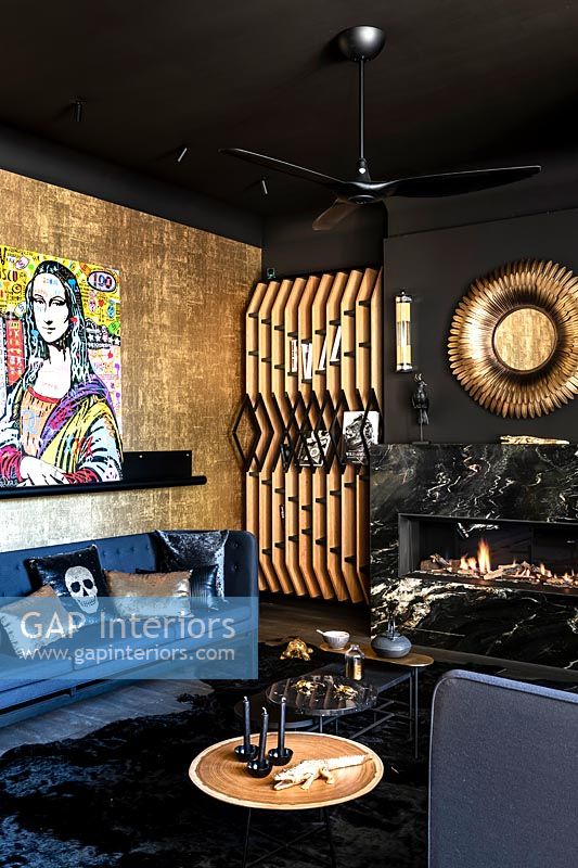 Eclectic modern living room with gold and black walls and modern artwork 