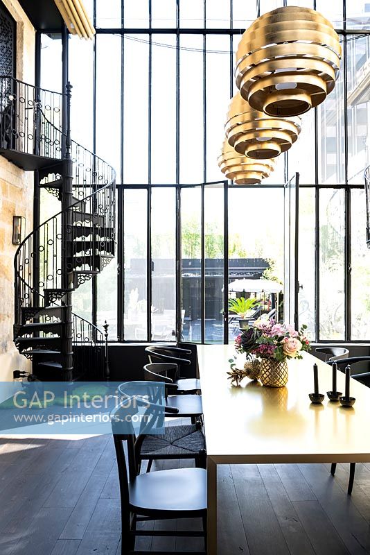 Large glass dining room with metal spiral staircase
