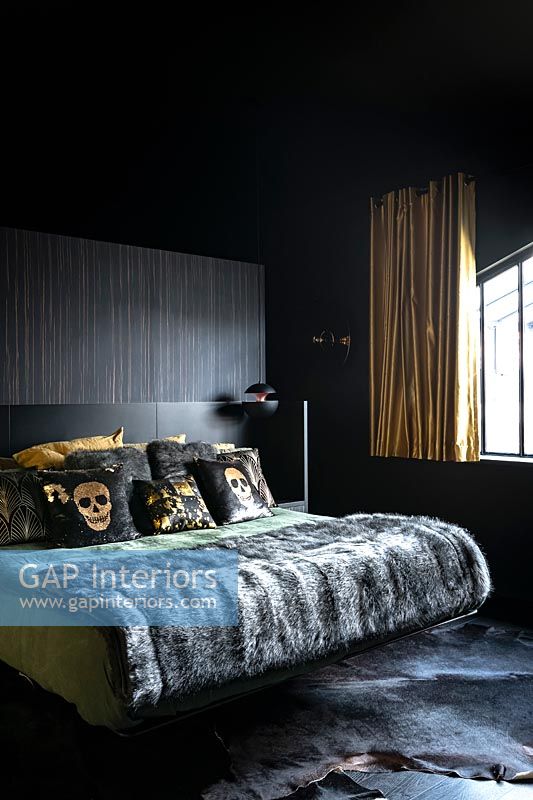 Modern bedroom with black walls and gold curtains 