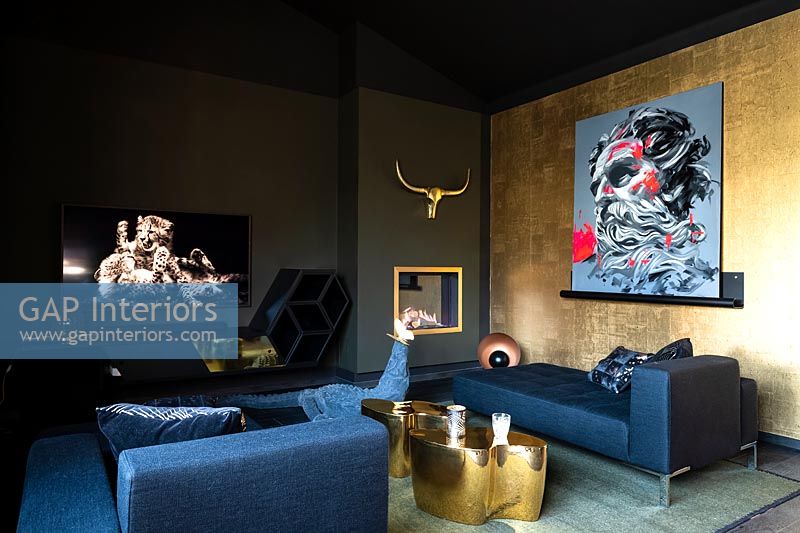 Black and gold modern bedroom with colourful artwork and large seating area