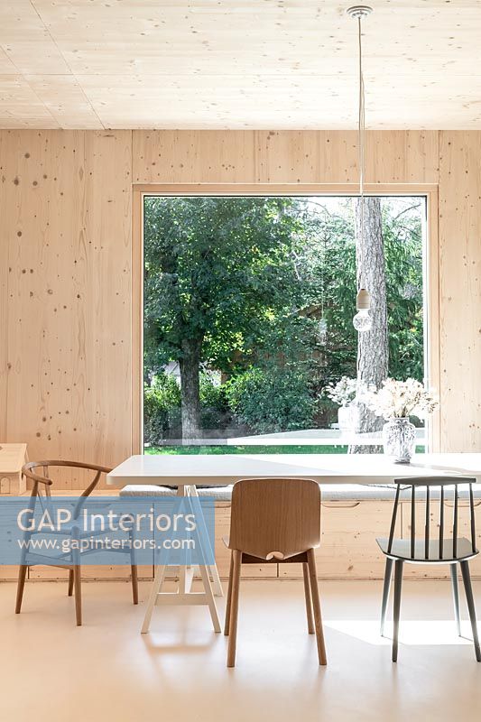 Modern timber clad country dining room with large picture window and views to garden