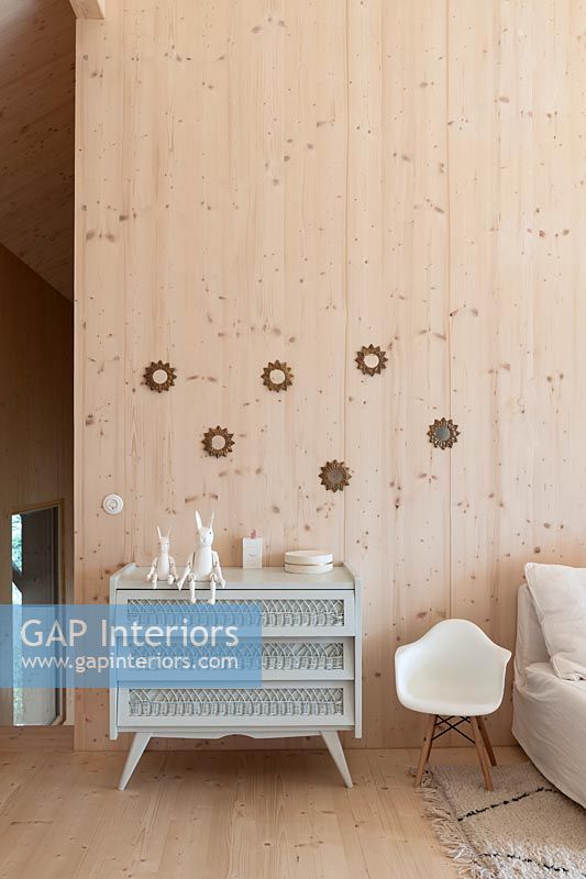 Pale grey chest of drawers in timber clad modern children's room 