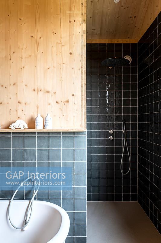 Black tiling and timber cladding in modern bathroom