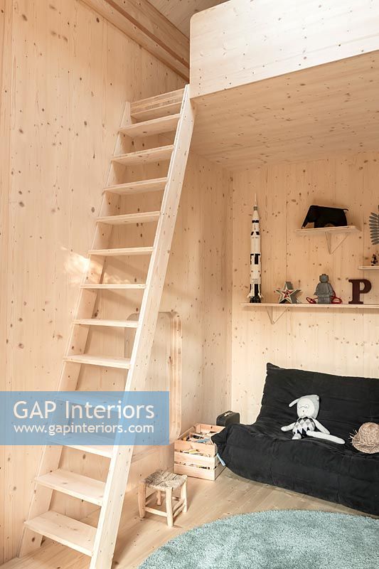 Timber clad children's room with ladder up to mezzanine bed 