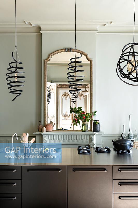 Modern kitchen island with black spiral pendant lights above