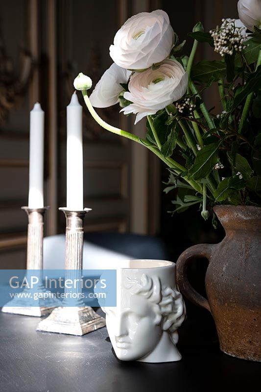 White roses on sideboard with candles