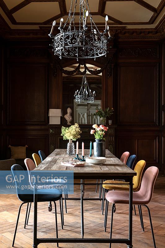 Modern dining table and mismatched chairs in classic dining room with period features