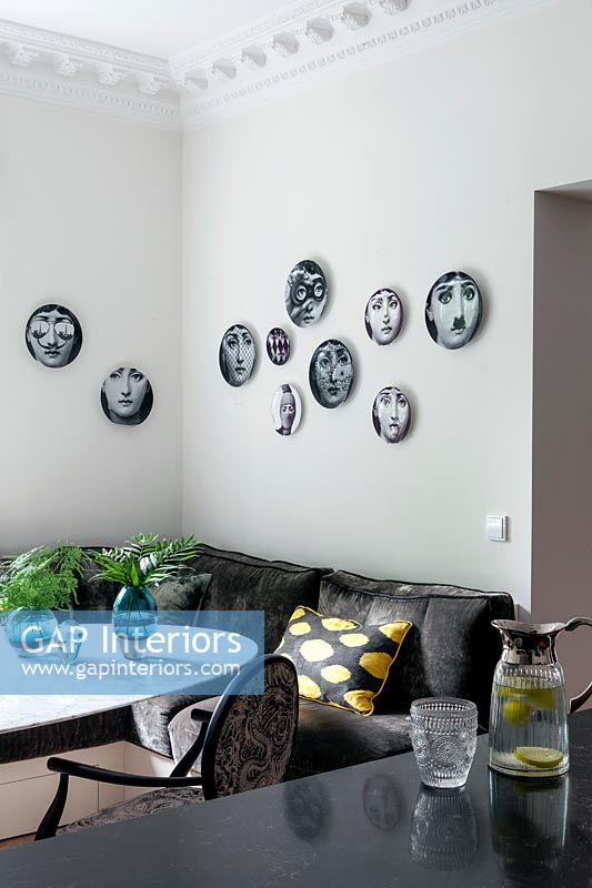 Wall display of decorative plates on dining area wall 