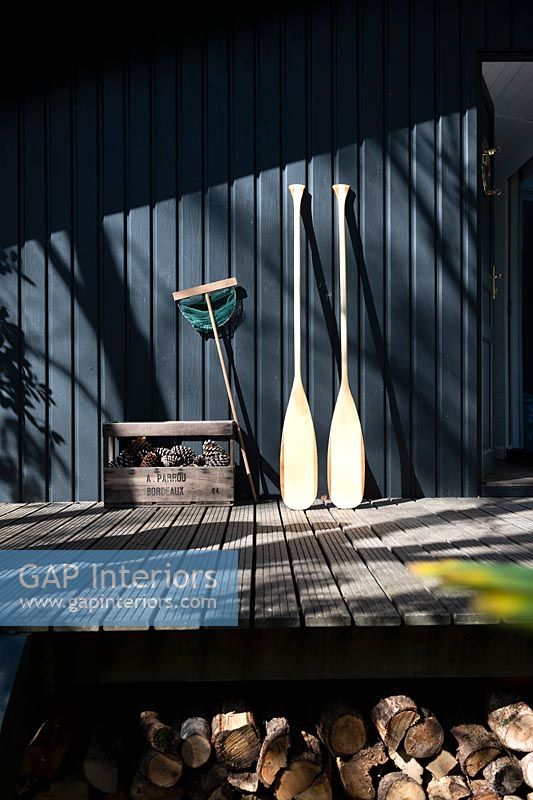 Set of oars leaning against a black painted wooden cabin 