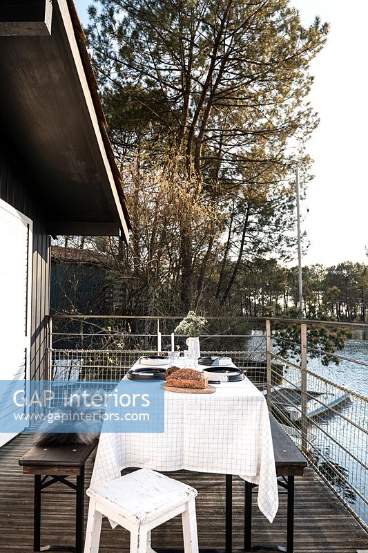 Outdoor dining area on small lakeside balcony 