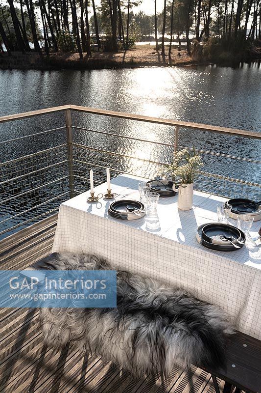 Outdoor dining table on lakeside balcony 