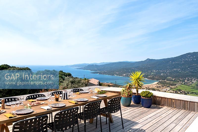 Large outdoor dining table on decked terrace with sea views 