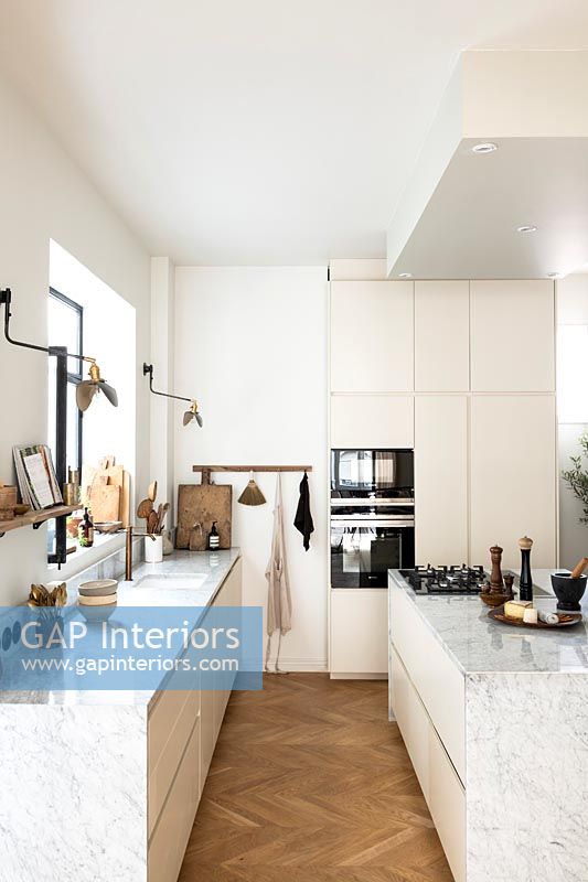 Modern white kitchen with parquet flooring 