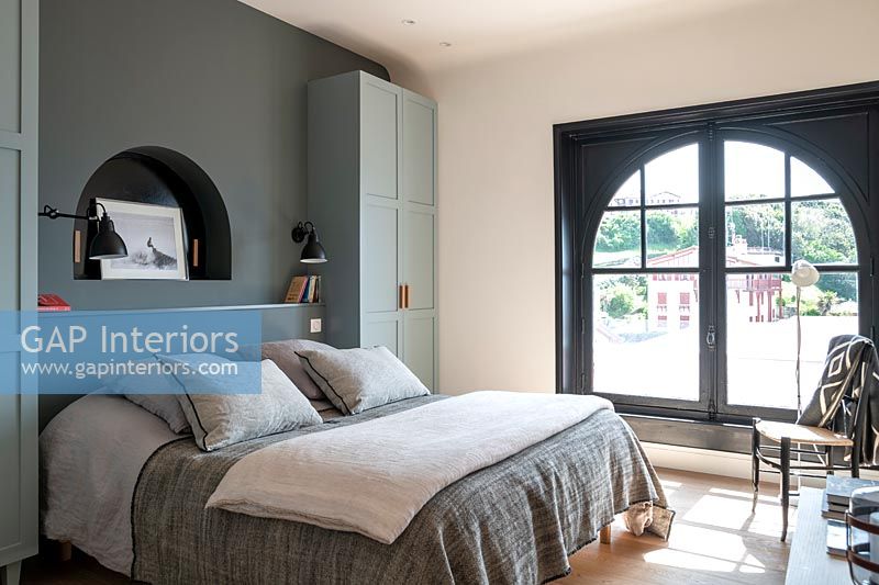 Grey modern bedroom with arched French windows 