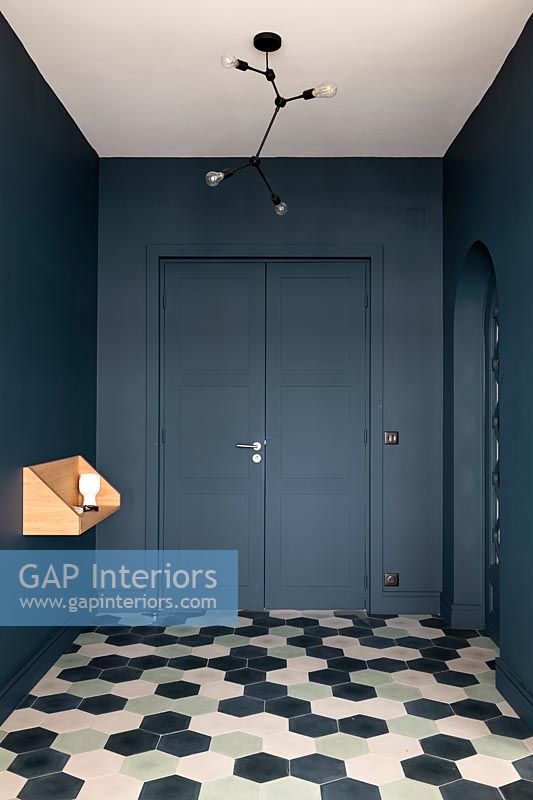 Modern hallway with dark grey painted walls and patterned flooring 
