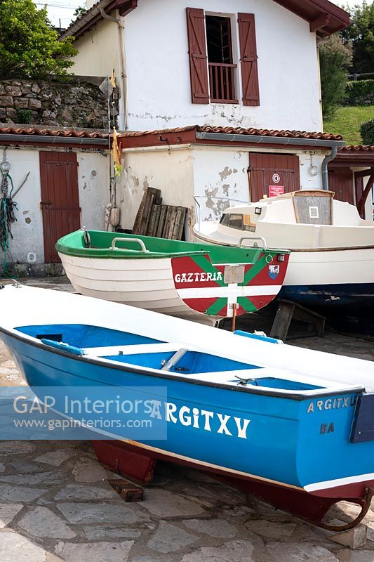 Wooden painted boats and rustic house exterior 