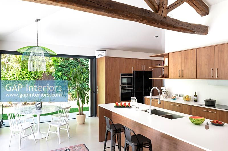 Modern kitchen-diner in open plan living space with exposed wooden beams