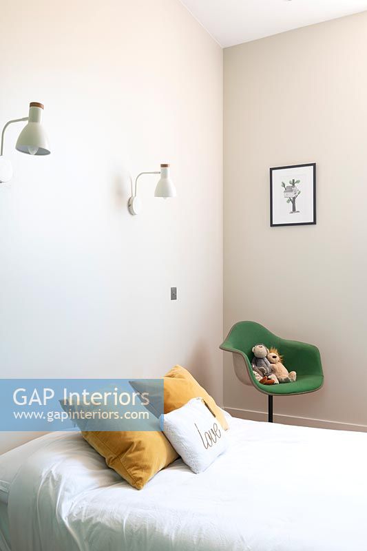 Green chair with toys in modern childrens bedroom 
