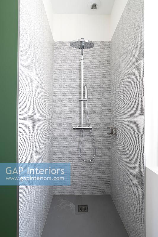 Grey tiling in modern shower cubicle 