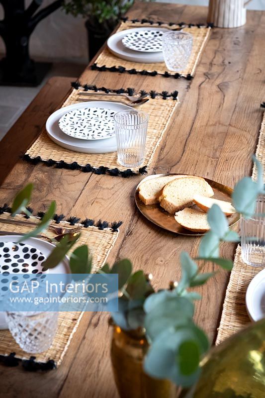Detail of outdoor wooden dining table laid for dinner 
