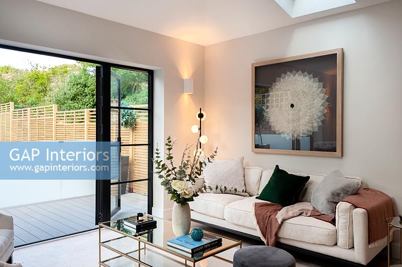 Contemporary living room with open patio doors to small decked terrace 