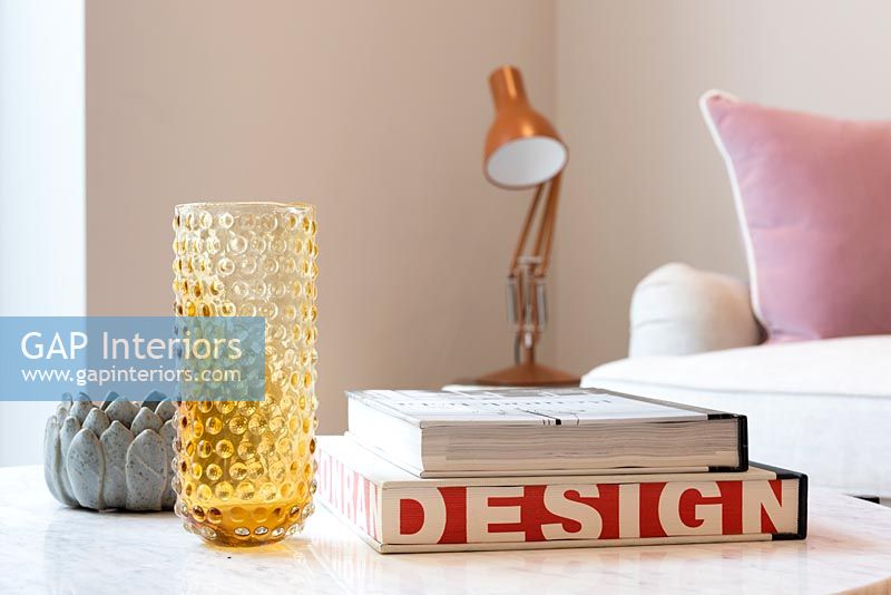 Detail of glassware and books on living room table 