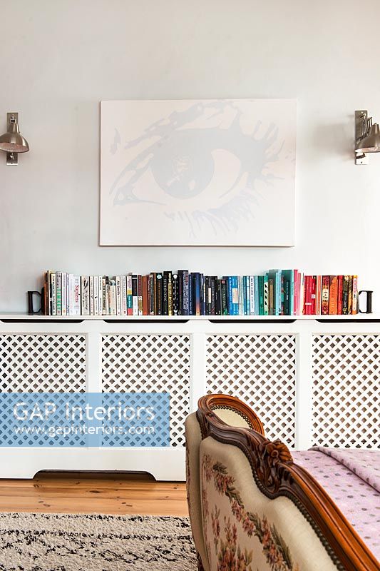 Large radiator cover with row of books on top 