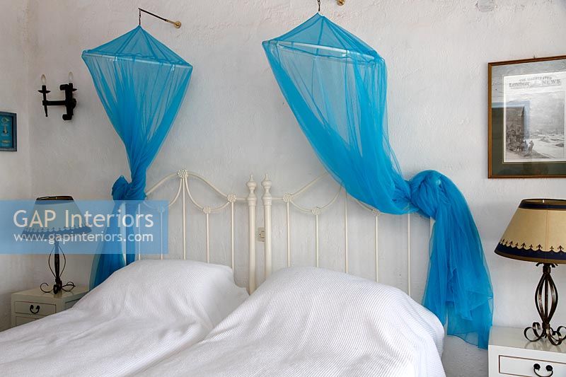 White country bedroom with blue canopies 