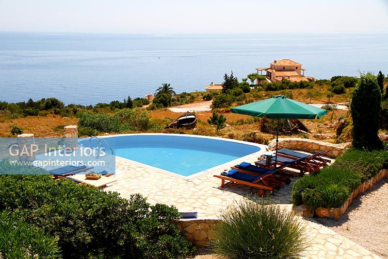 Overview of outdoor living area around swimming pool with sea view 