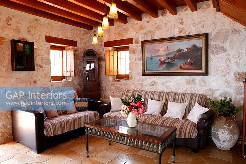 Country living room with exposed wooden beams and stone walls 