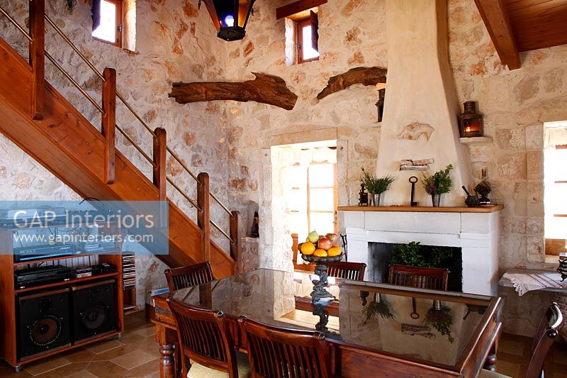 Country dining room with exposed wooden beams and stone walls 