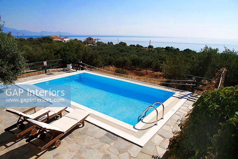 Overview of swimming pool with recliners and scenic views 