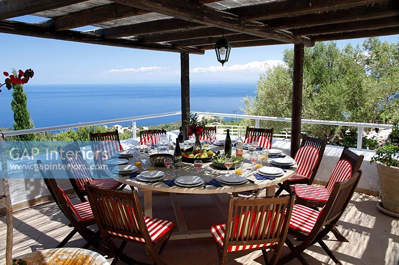 Large circular outdoor dining room under pergola with sea views from terrace 