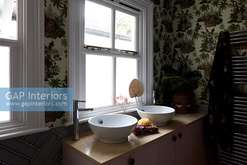 Patterned wallpaper and double sinks in modern bathroom 