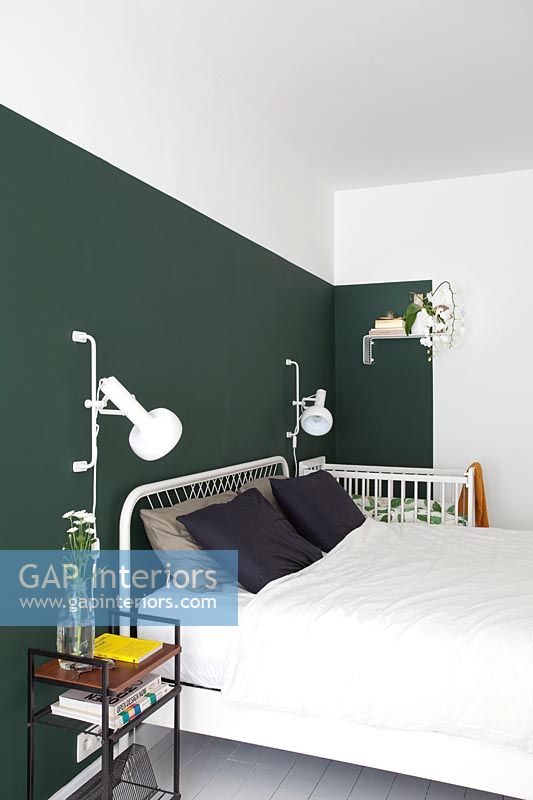 Green feature wall in white modern bedroom 