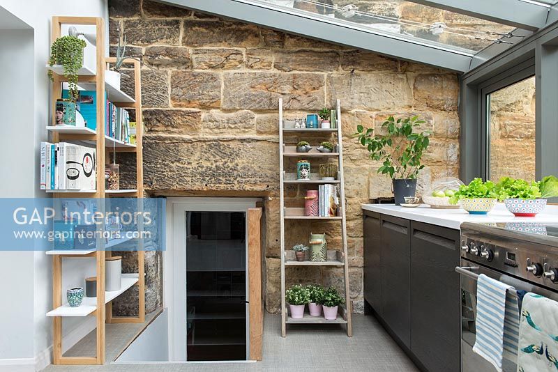 Modern kitchen extension with view of stone house and door 