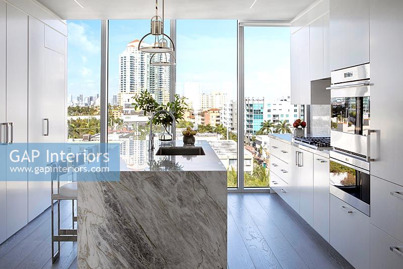 Contemporary kitchen with city views through large glass wall 