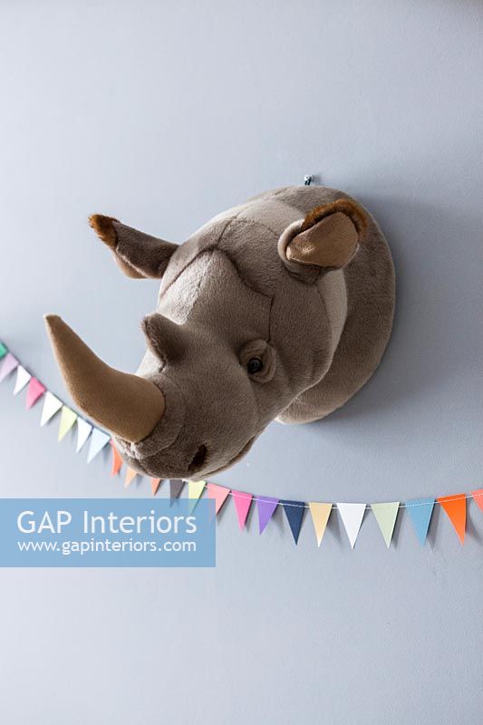 Soft toy trophy head of a rhino on wall 