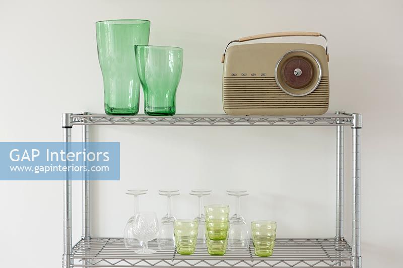 Retro radio and glassware on metal shelf unit 