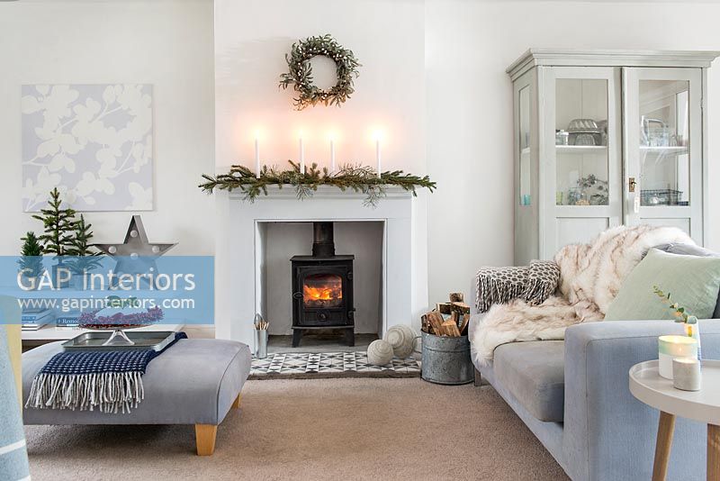 Lit wooden burning stove in modern country living room at Christmas 